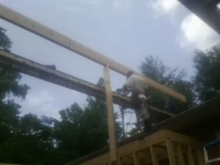 Carpenter setting a ridge beam over a new addition frame — Ice Dam Removal by Roofing Brothers in La Quinta