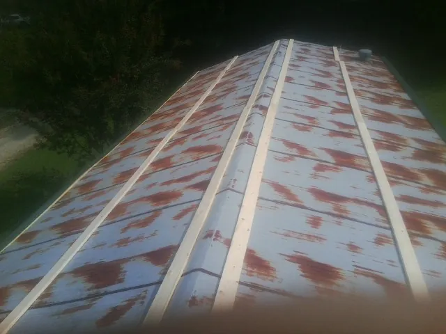 Rusted metal roof panels with new wood purlins before replacement — Storm Damage Roof Repair in La Quinta by Roofing Brothers