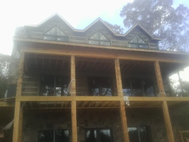 Dormers and porch framing on a large log home under construction — Roof Coating work by our crew in La Quinta