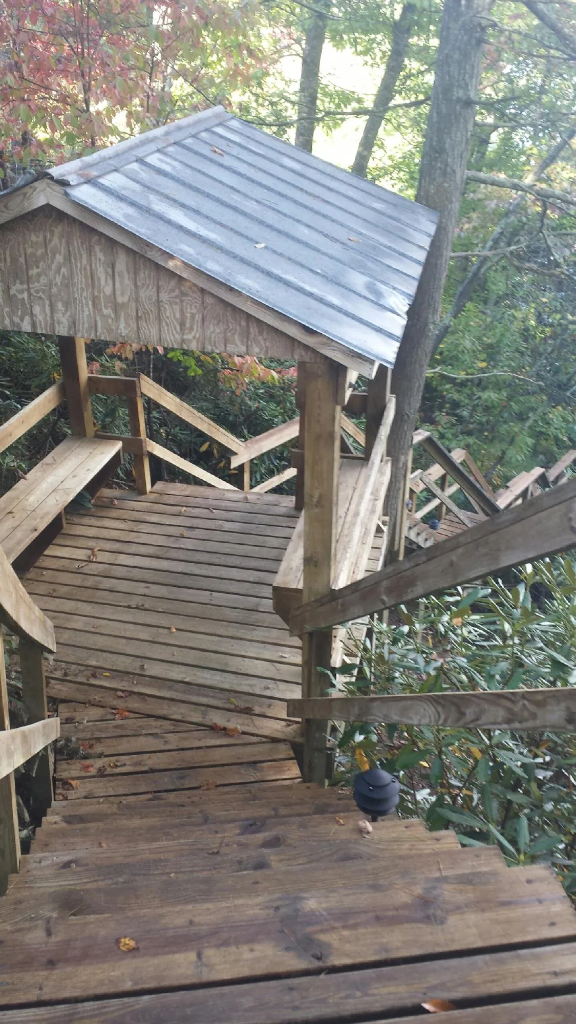 Metal roofed shelter over wooden steps on a wooded walkway — Skylight Repair & Installation work by our crew in La Quinta